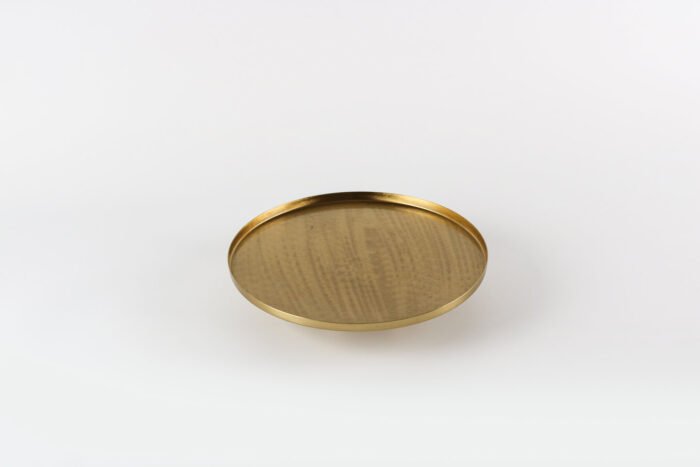 Modern gold display tray with elevated base and decorative items.