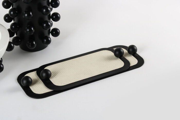 Sleek Minimal Tray with Black Accents – cream leather tray with black border and sculptural handles.