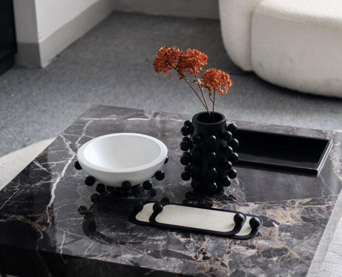 Sleek Minimal Tray with Black Accents – cream leather tray with black border and sculptural handles.