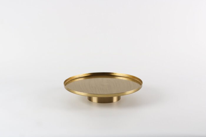 Modern gold display tray with elevated base and decorative items.