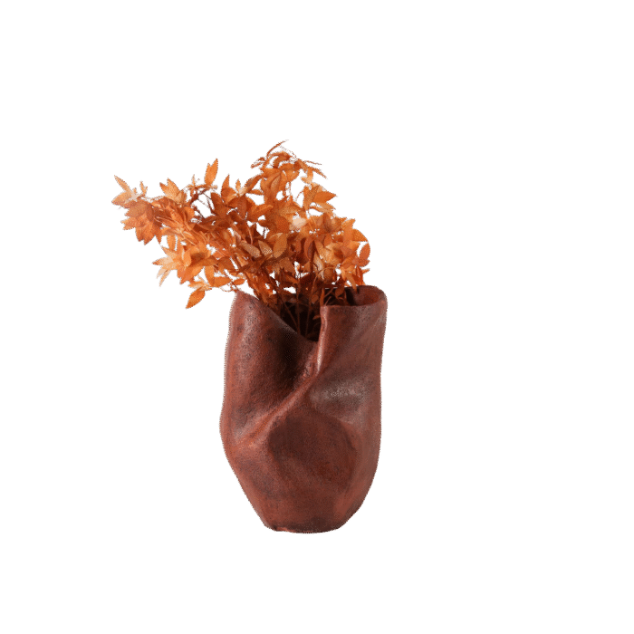 Sculptural red vase with a matte twisted silhouette, styled with warm dried florals for artistic modern home decor.